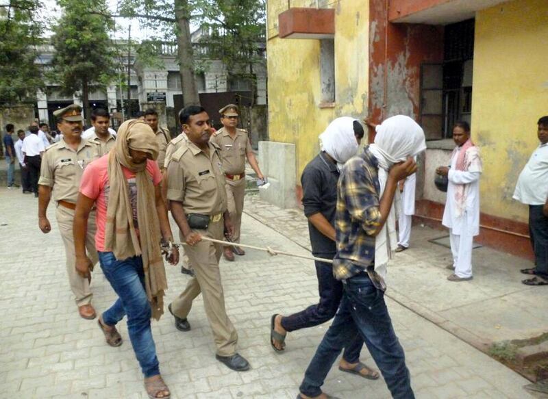 Indian police escort three suspects arrested in connection with a video posted on social media showing a sexual assualt at the district court in Rampur in May 29, 2017. 
Indian police arrested three men who put up video on social media showing them assaulting two women in broad daylight as a dozen others watched, ignoring screams for help. Blurry video aired on Indian broadcasters showed the men groping and pushing the women in Uttar Pradesh state as onlookers laughed and filmed the assault. / AFP PHOTO / STR