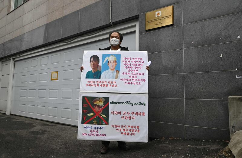 A protester holds a placard during a demonstration condemning the military coup in Myanmar, in front of the military office of the Myanmar embassy in Seoul.  AFP