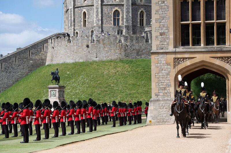 Members of the Household Cavalry, right, arrive as members of the F Company Scots Guards stand to attention. AFP