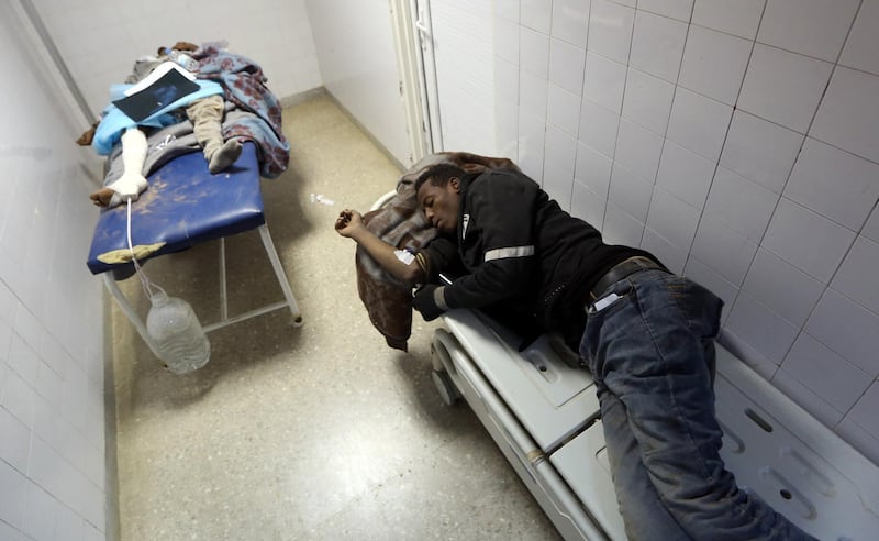 African migrant, who were injured after their vehicle was overturned during a truck collision, sleep on beds in a hospital room in the town of Beni Walid, 170 kilometres southeast of the capital Tripoli, on February 14, 2018.
At least 19 migrants were killed and more than 100 injured when the truck transporting them crashed in Libya on February 14, a hospital said.
More than 300 migrants, mostly Eritrean and Somali nationals, were on board the vehicle which overturned near the town of Bani Walid. / AFP PHOTO / MAHMUD TURKIA