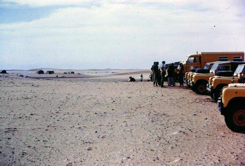 Philip Horniblow (Director of Health, Abu Dhabi, in light shirt) leading a medical ‘hearts and minds’ exercise to bring health services to the western region, 1968-1969.
The huts to the left are possible those of Mansouri , around Al Gayathi (Athol checking this statement)
The exercise was run by Medical Services, Abu Dhabi Defence Force (ADDF).  The Bedford is an ADDF ambulance.
Photo: Major R. Hitchcock, OC A Squadron & subsequently founding officer 2nd Infantry Regiment, ADDF, 1967-70, telephone +44 1394 410173
