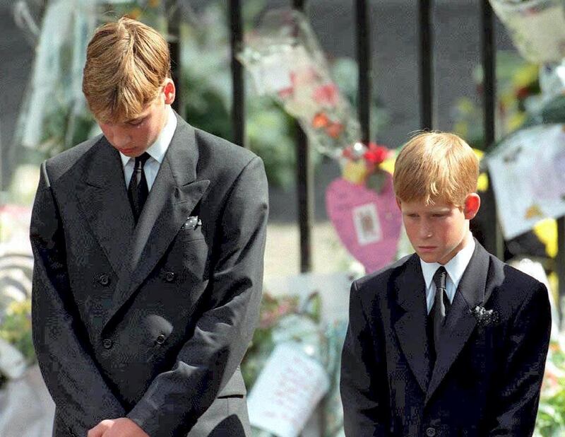 Prince William (left) and Prince Harry, the sons of Diana, Princess of Wales, bow their heads as their mother's coffin is taken out of Westminster Abbey 06 September following her funeral service. The princess was killed 31 August in a car crash in Paris. (Photo by ADAM BUTLER / POOL / AFP)