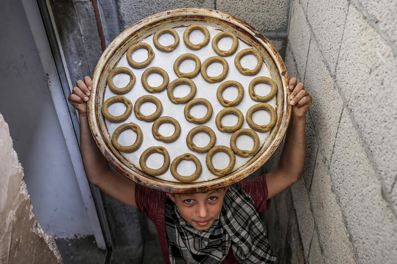 A Palestinian boy carries a tray of traditional cookies in preparation for the upcoming Eid al-Fitr holiday which marks the end of the Islamic holy month of Ramadan, in the southern Gaza Strip city of Rafah.   AFP