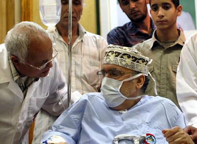 Freed Lockerbie bomber Abdelbaset Ali Mohmet al-Megrahi speaks to a doctor as he wears a medical and sits on a wheelchair during a meeting with an African delegation at a hospital in Tripoli on September 9, 2009. Megrahi, who was controversially granted early release on August 20 by Scottish authorities on compassionate grounds, received a 150-strong African delegation in a Libyan hospital, his first public appearance since his admission with terminal cancer, an AFP correspondent reported. AFP PHOTO/MAHMUD TURKIA (Photo by MAHMUD TURKIA / AFP)