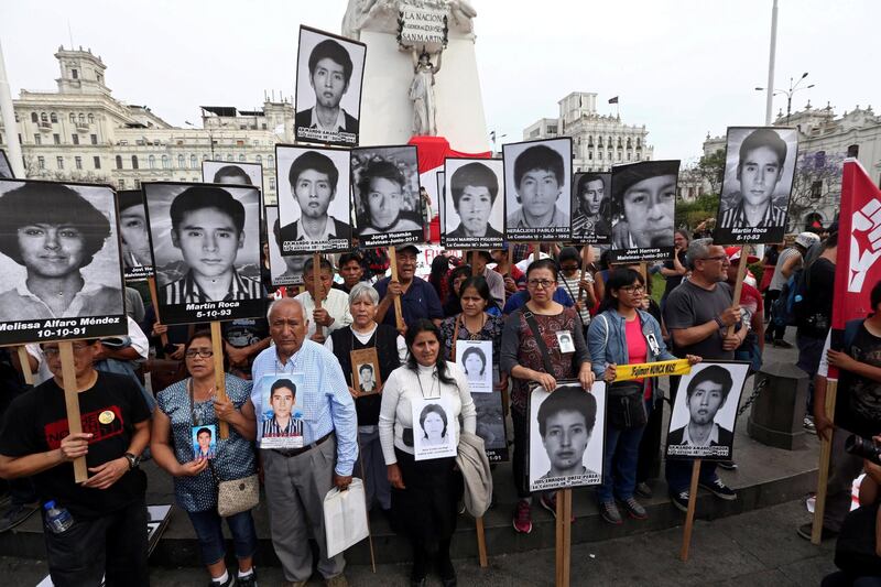 People holding pictures of victims of the guerrilla conflict in the 80s and 90s march after Peruvian President Pedro Pablo Kuczynski pardoned former President Alberto Fujimori in Lima, Peru, December 25, 2017. REUTERS/Mariana Bazo          NO RESALES. NO ARCHIVES.     TPX IMAGES OF THE DAY