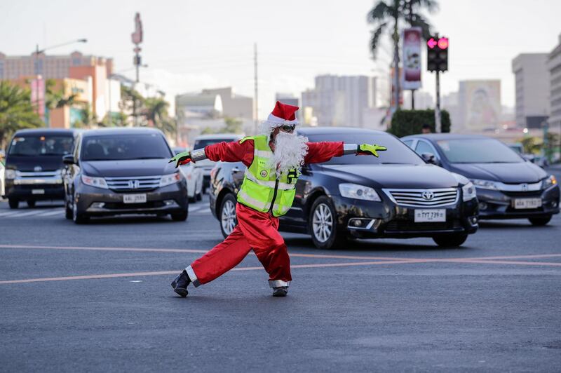 Filipino traffic officer Ramiro Hinojas directs motorists wearing a Santa costume in Pasay, Manila. EPA