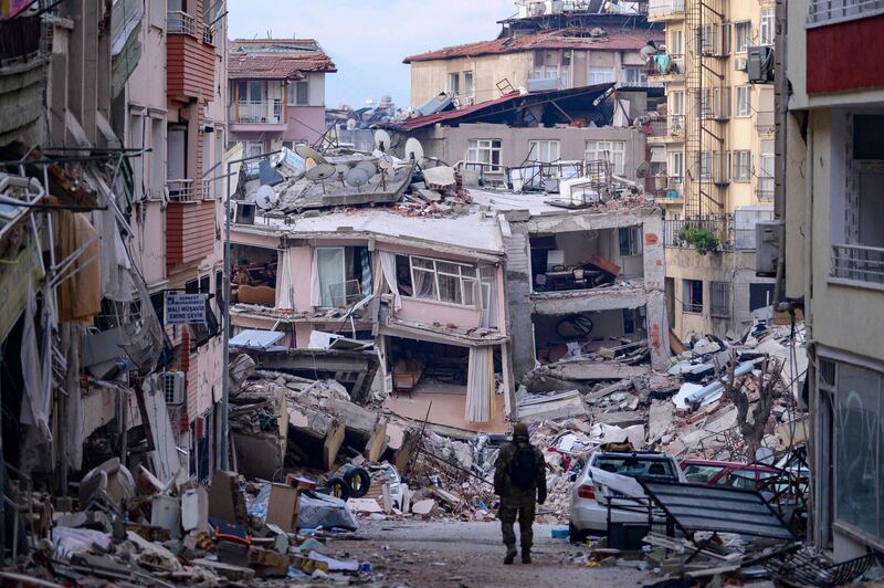 A Turkish soldier walks among destroyed buildings in Hatay. AFP
