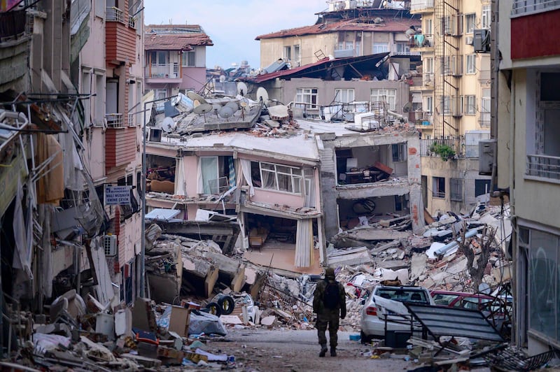 A Turkish soldier walks among destroyed buildings in Hatay. AFP