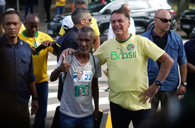 Mr Bolsonaro  poses with a supporter after voting in Rio de Janeiro. AFP