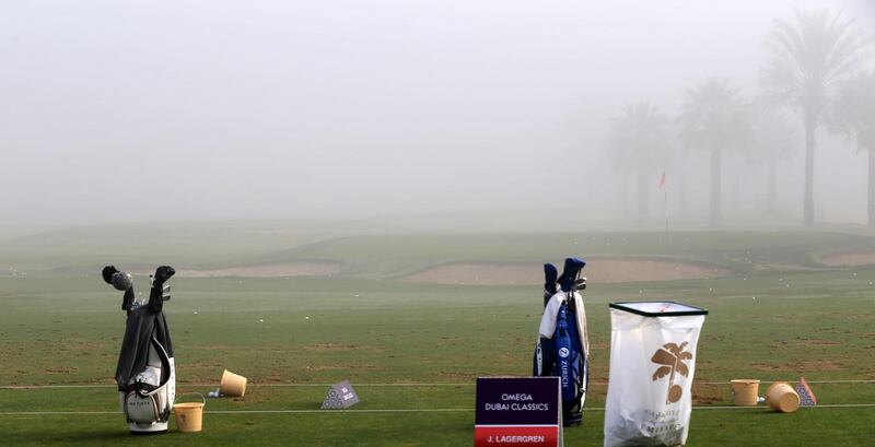 Golf clubs are seen on the driving range as fog delays the start of the round two of the Dubai Desert Classic at Emirates Golf Club on January 26, 2018, in Dubai. / AFP PHOTO / Karim SAHIB