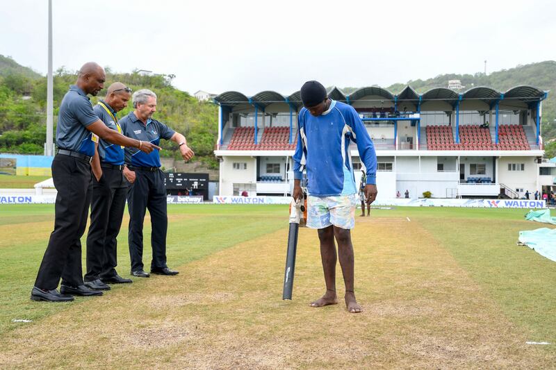 Match officials Gregory Brathwaite (L), Joel Wilson (2L) and Richard Illingworth inspect the pitch after rain delayed the start of the fourth day of the Second Test between Bangladesh and the West Indies at Darren Sammy Cricket Ground, Gros Islet, Saint Lucia. AFP