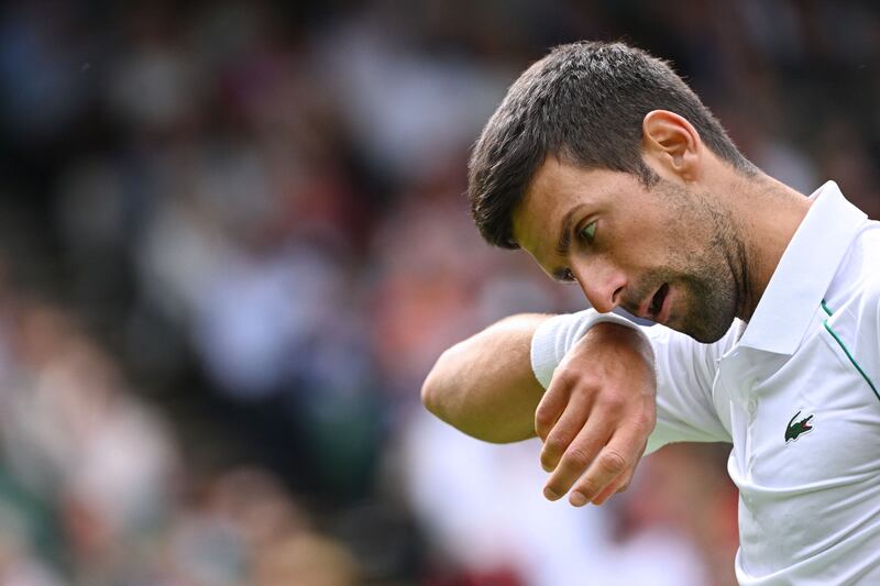 Djokovic wipes his face as he competes against Australia's Thanasi Kokkinakis. AFP