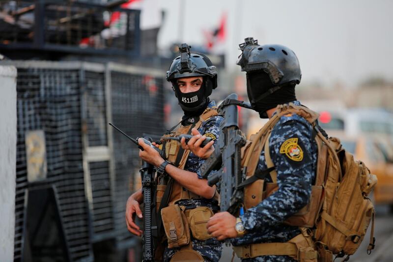 Members of Iraqi federal police are seen with military vehicles in a street in Baghdad, Iraq. REUTERS