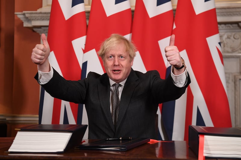 Mr Johnson gives a thumbs-up gesture after signing the Brexit trade deal with the EU in No 10, Downing Street, in December 2020. Getty Images