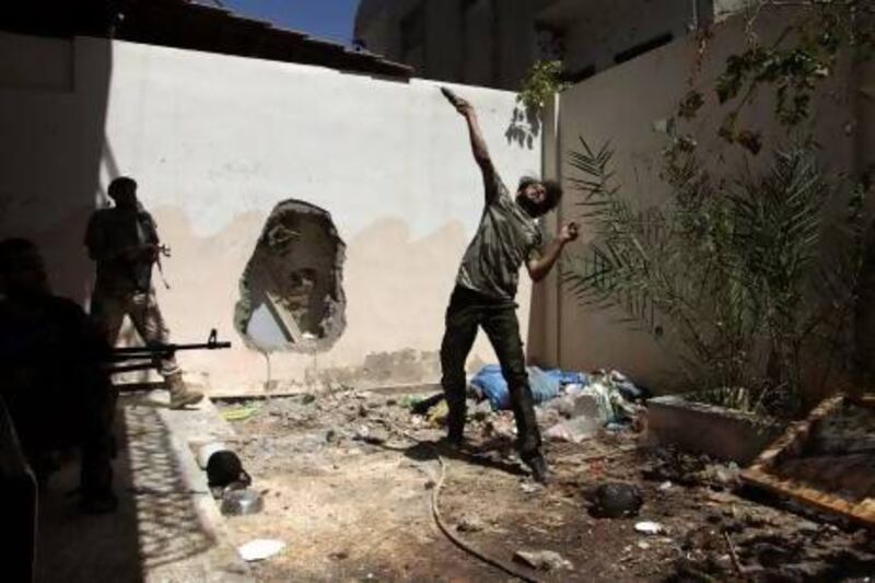 A Free Syrian Army fighter throws a homemade bomb towards forces loyal to Syria's President Bashar Al Assad as fellow fighters watch in Deir Al Zor
