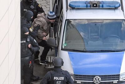 Stephan Balliet (C), who shot dead two people after an attempt to storm a synagogue in Halle an der Saale, eastern Germany, gets into a police car after his verdict was spoken on the 26th day of his trial on December 21, 2020 at the district court in Magdeburg, eastern Germany. The court handed down a life sentence to the assailant behind a deadly far-right attack that nearly became the country's worst anti-Semitic atrocity since World War II. After failing to storm the Halle synagogue on October 9, 2019, the attacker, Stephan Balliet, 28, shot dead a female passer-by and a man at a kebab shop. / AFP / POOL / Hendrik Schmidt
