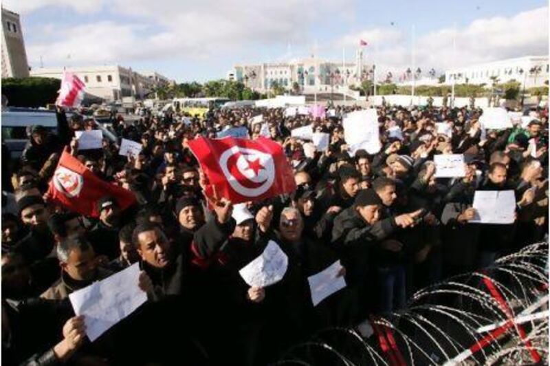 Tunisians, among them policemen, gather to ask for the right to form unions and better salaries as the vehicle of Tunisia's interim president, Fouad Mbazaa, arrives at the government palace in Tunis.