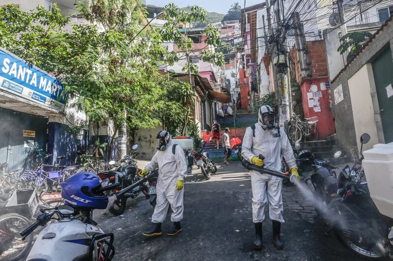 Workers perform disinfection operations at Dona Marta favela in Rio de Janeiro, Brazil. Bloomberg