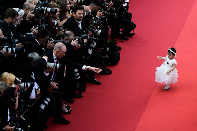 A young guest in front of photographers on the red carpet before the screening of 'Final Cut', at the 75th Cannes Film Festival. AFP