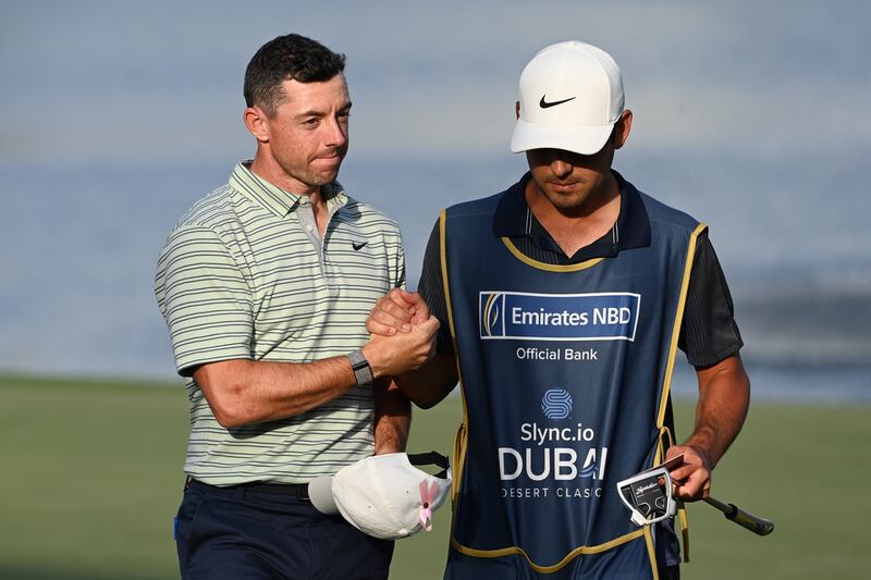 Rory McIlroy of Northern Ireland walks off the 18th hole with his caddie at Emirates Golf Club. Getty
