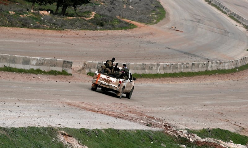 Fighters drive through Idlib city center from Saraqeb in Idlib province, Syria. REUTERS