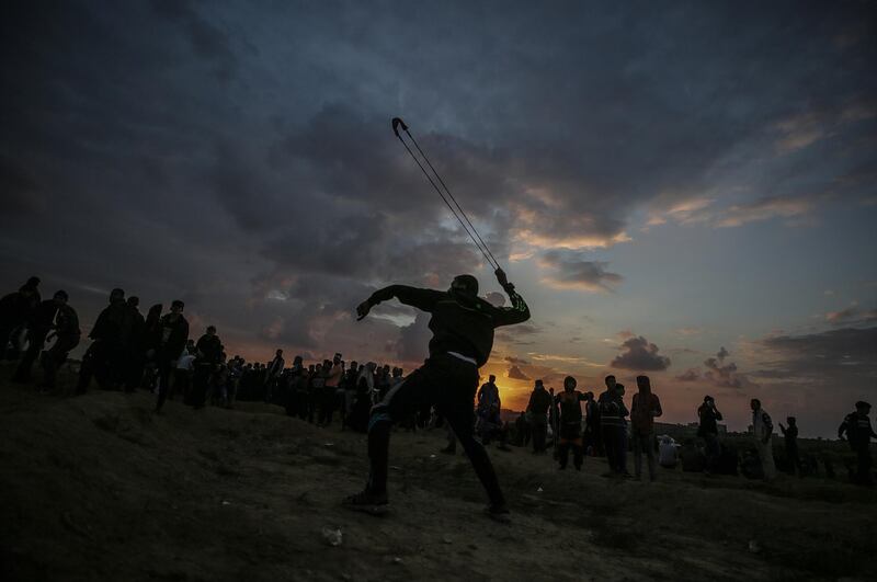 Palestinian protesters throw stones at Israeli troops during the clashes after Friday protests near the border between Israel and Gaza Strip in the east Gaza Strip.  EPA