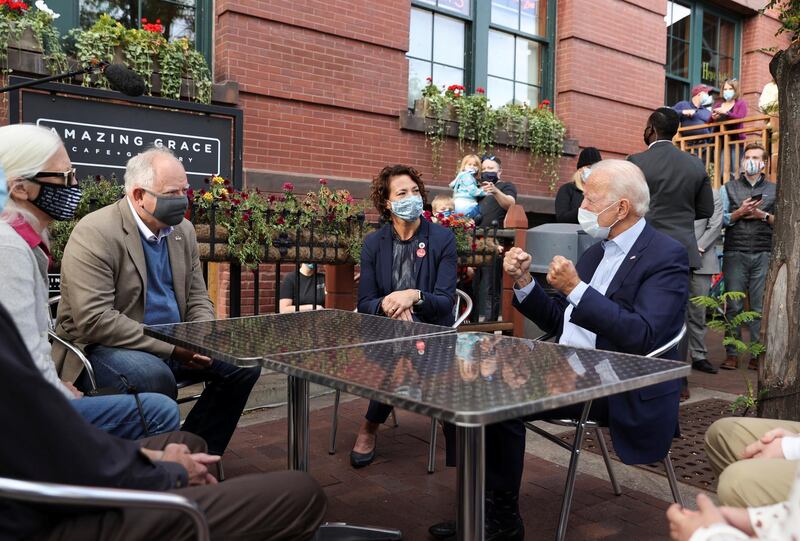 Democratic US presidential nominee and former Vice President Joe Biden speaks with Minnesota Governor Tim Walz, Duluth Mayor Emily Larson and others as he sits down with supporters outside a coffee shop during an unscheduled campaign stop in Duluth, Minnesota, September 18, 2020. Reuters