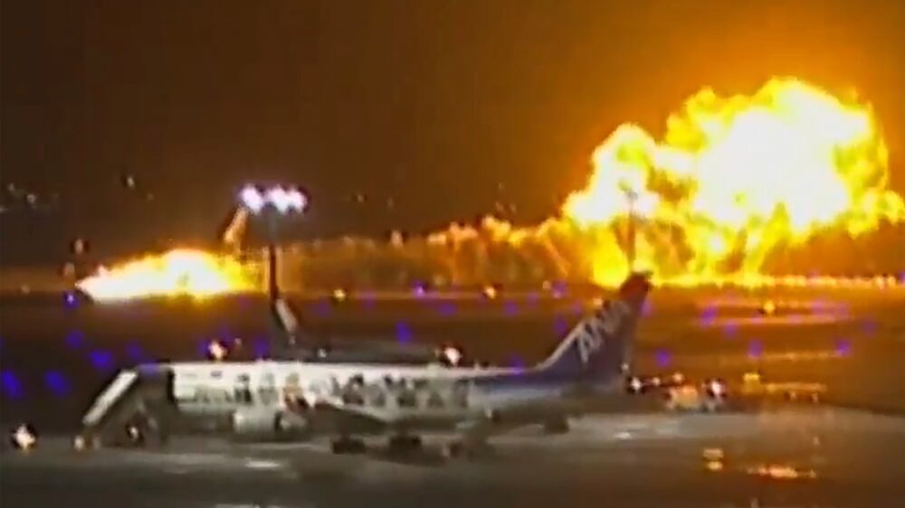 Moment Japan Airlines plane bursts into flames on landing