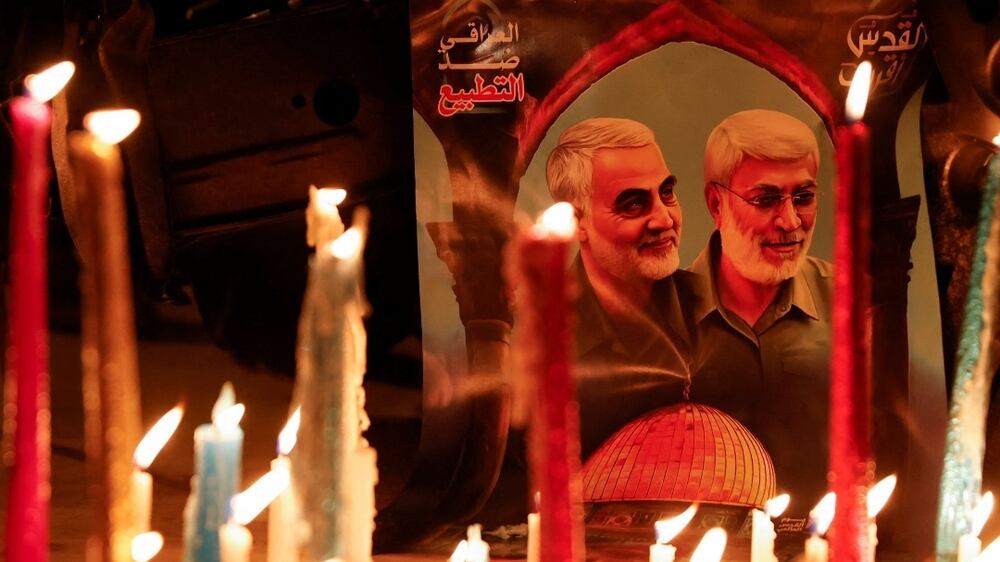 Lit candles are placed next to a picture of Iranian military commander General Qassem Soleimani and Iraqi militia leader Abu Mahdi al-Muhandis during the second anniversary of their killing in a U. S.  attack, at Baghdad Airport in Baghdad, Iraq, January 2, 2022.  REUTERS / Saba Kareem