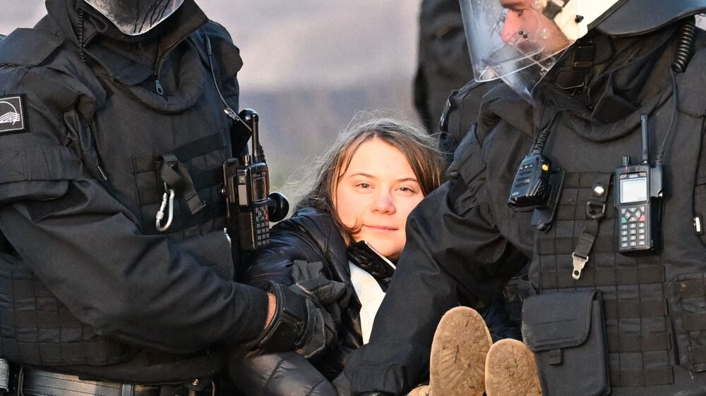Police officers carry Swedish climate activist Greta Thunberg (C) out of a group of demonstrators and activists in Erkelenz, western Germany, on January 17, 2023, as demonstrations continue against a coal mine extension in the nearby village of Luetzerath.  - Already abandoned by its original residents, Luetzerath has become a symbol for resistance against fossil fuels.  Energy giant RWE has permission for the expansion of the mine under a compromise agreement that also includes that RWE will stop producing electricity with coal in western Germany by 2030 -- eight years earlier than previously planned.  With Russia's gas supply cut in the wake of the invasion of Ukraine, Germany has had recourse to coal, firing up mothballed power plants.  (Photo by Federico Gambarini  /  dpa  /  AFP)  /  Germany OUT