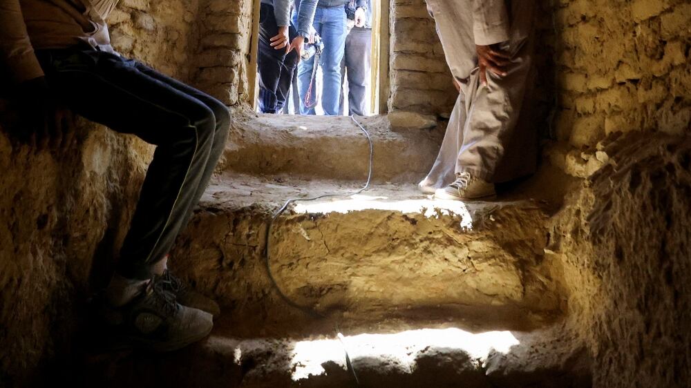 A man sits inside a tomb after the announcement of the discovery of 4,300-year-old sealed tombs, which have made a number of important archaeological discoveries dating to the fifth and sixth dynasties of the Old Kingdom, also stated that the expedition had found a group of Old Kingdom tombs, indicating that the site comprised a large cemetery, where the most important tomb belonged to Khnumdjedef, an inspector of the officials, a supervisor of the nobles, and a priest in the pyramid complex of Unas, the last kind of the fifth dynasty, in Egypt's Saqqara necropolis, in Giza, Egypt, January 26, 2023.  REUTERS / Mohamed Abd El Ghany
