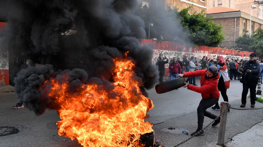 A protester throws a burning tire during a protest outside the Lebanese Central Bank against the monetary policies of the Lebanese Central Bank governor Riyad Salameh in Beirut, Lebanon, 25 January 2023.  The Lebanese pound has lost about 95 percent of its value against the dollar, Lebanese people grow desperate to get back their money as the Lebanese pound's value on 25 January hit an all-time low, now trading at 56,800 to the US dollar in the black market.   EPA / WAEL HAMZEH