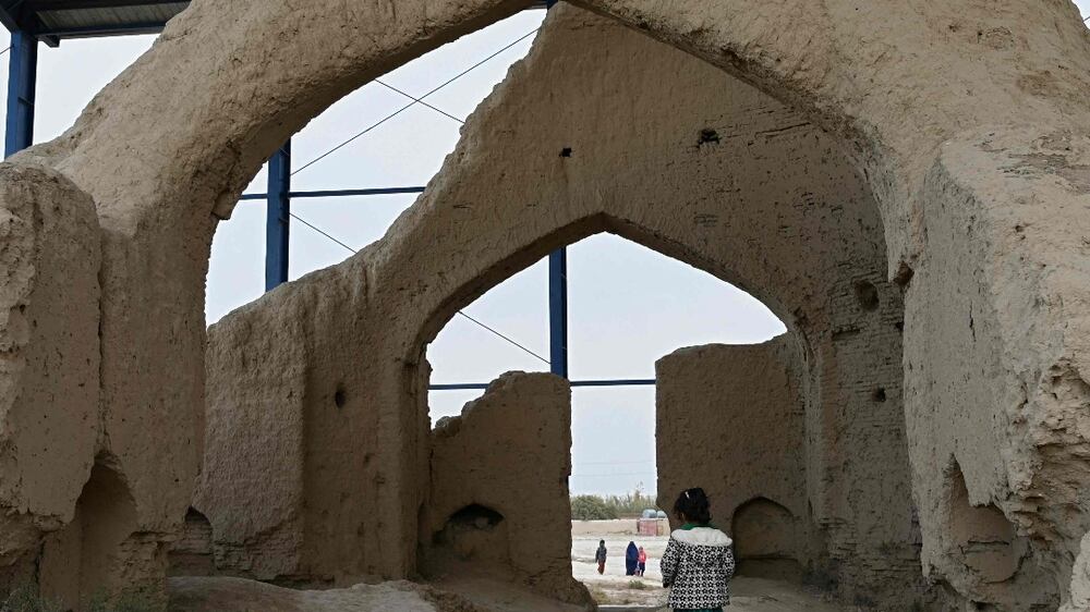 An Afghan girl walks through the ruins of the house of Sufi mystic and poet Rumi, in Balkh province on October 28, 2021.  (Photo by WAKIL KOHSAR  /  AFP)