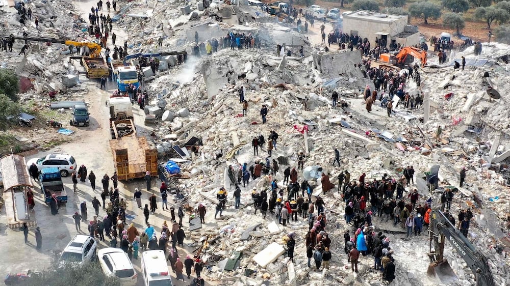 This aerial view shows residents, aided by heavy equipment, searching for victims and survivors amidst the rubble of collapsed buildings following an earthquake in the village of Besnia near the twon of Harim, in Syria's rebel-held noryhwestern Idlib province on the border with Turkey, on February 6, 2022.  - Hundreds have been reportedly killed in north Syria after a 7. 8-magnitude earthquake that originated in Turkey and was felt across neighbouring countries.  (Photo by Omar HAJ KADOUR  /  AFP)
