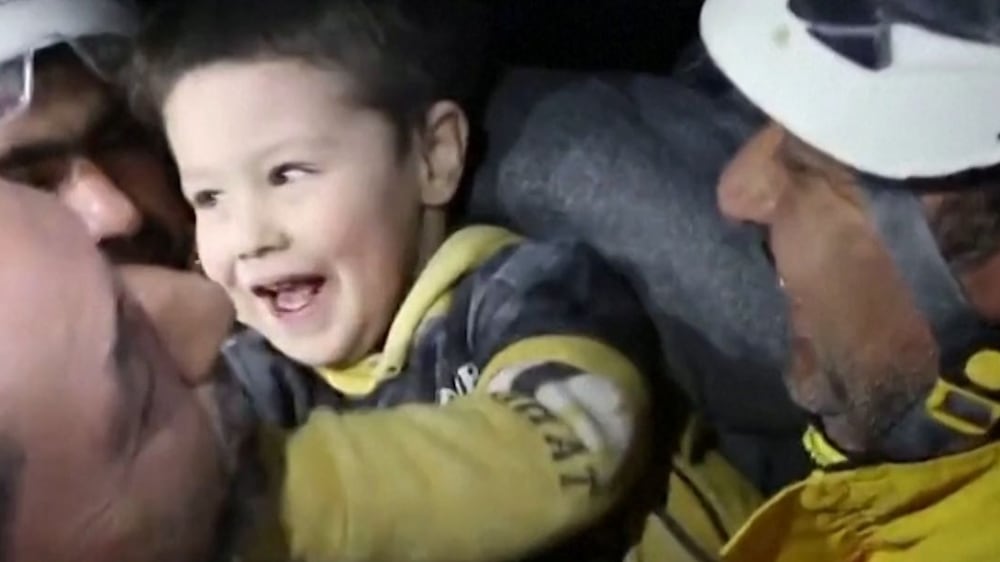 Moment Syrian boy smiles after being pulled from the rubble