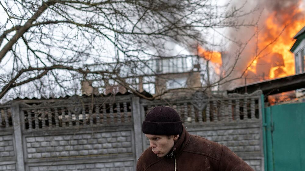 A local resident reacts as a house is on fire after heavy shelling on the only escape route used by locals to leave the town of Irpin, while Russian troops advance toward the capital, 24km from Kyiv, Ukraine March 6, 2022.  REUTERS / Carlos Barria