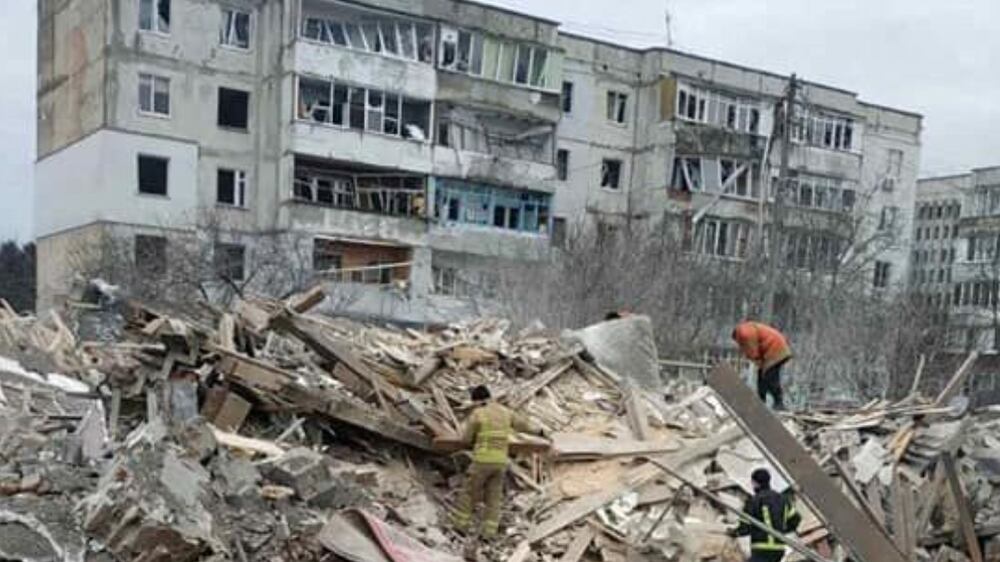 People are seen among debris of residential buildings damaged by shelling, amid the Russian invasion of Ukraine, in Zhytomyr region, Ukraine, in this handout picture released March 7, 2022.   Press service of the State Emergency Service of Ukraine/Handout via REUTERS ATTENTION EDITORS - THIS IMAGE HAS BEEN SUPPLIED BY A THIRD PARTY. 