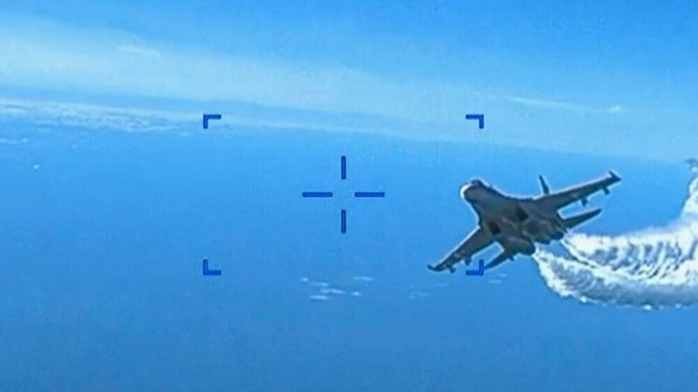 This photo taken from video released on Thursday, March 16, 2023, shows a Russian Su-27 approaching the back of the MQ-9 drone and beginning to release fuel as it passes, over the Black Sea, the Pentagon said.  The Pentagon has released footage of what it says is a Russian aircraft conducting an unsafe intercept of a U. S.  Air Force surveillance drone in international airspace over the Black Sea.  (US Department of Defense via AP)