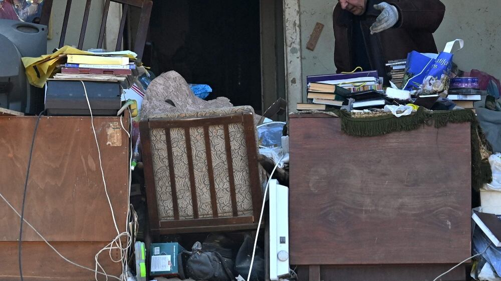 A local resident throws away damaged items as he retrieves what he can from his destroyed apartment, located in a five-storey residential building that partially collapsed after shelling the day before by Russian troops trying to encircle the Ukrainian capital as part of their slow-moving offensives, in Kyiv on March 20, 2022.  (Photo by Sergei SUPINSKY  /  AFP)