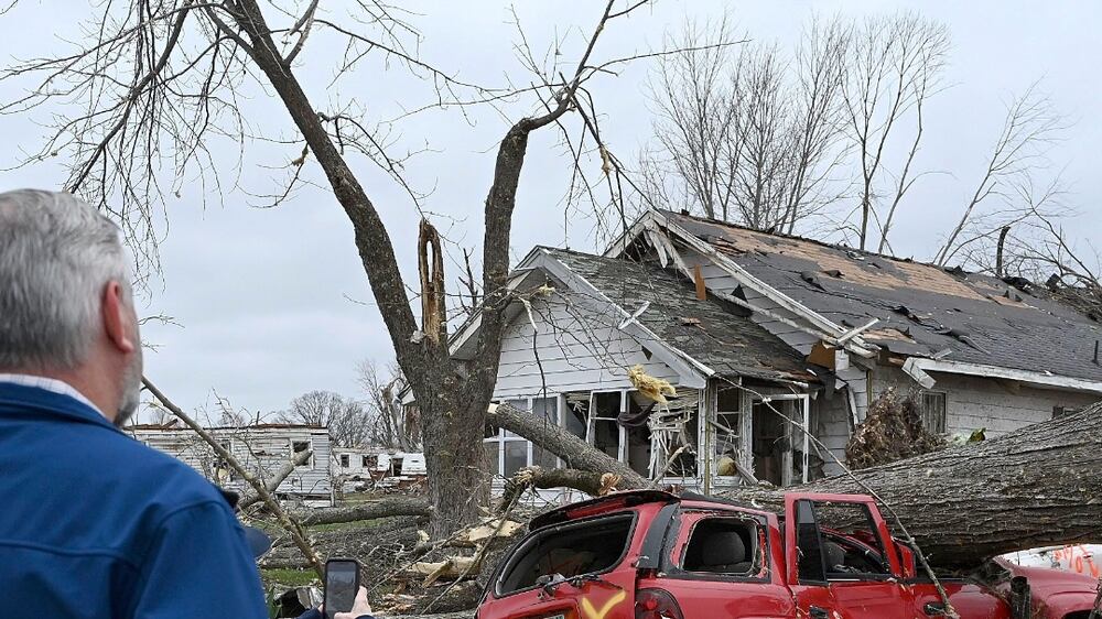 Sullivan Mayor Clint Lamb and Indiana Governor Eric Holcomb survey the damage caused by a tornado on Saturday, April 1, 2023 in Sullivan, Indiana.  (Joseph C.  Garza / The Tribune-Star via AP)