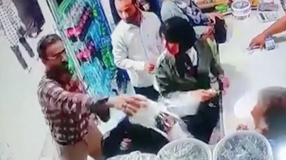 Screengrab from Reuters video showing a man in Iran throwing yogurt on two women for not covering their hair