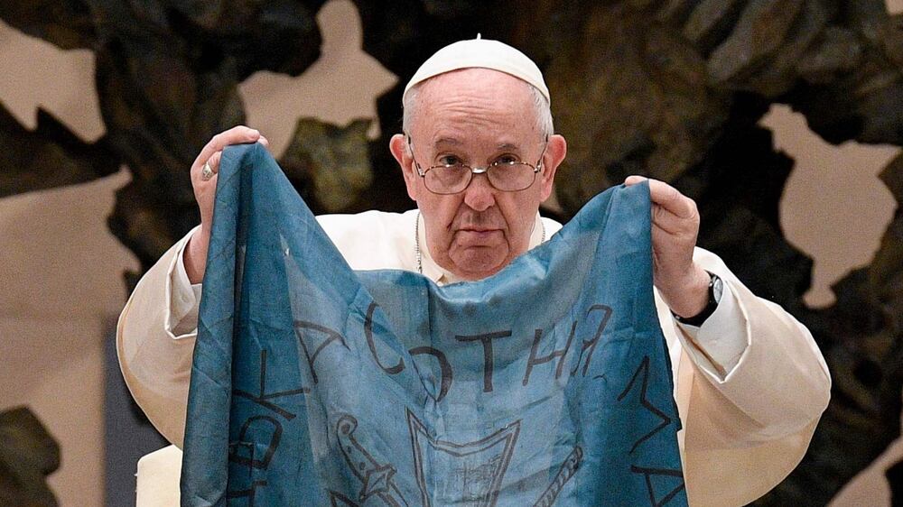 This photo taken and handout by The Vatican Media on April 6, 2022 shows Pope Francis holding a flag of Ukraine that comes from the city of Bucha, one of the areas around Ukraine's capital from which Russian troops have withdrawn and where dozens of bodies in civilian clothing have been found, during the weekly general audience on April 6, 2022 at Paul-VI hall in The Vatican.  (Photo by Handout  /  VATICAN MEDIA  /  AFP)  /  RESTRICTED TO EDITORIAL USE - MANDATORY CREDIT "AFP PHOTO  /  VATICAN MEDIA" - NO MARKETING - NO ADVERTISING CAMPAIGNS - DISTRIBUTED AS A SERVICE TO CLIENTS