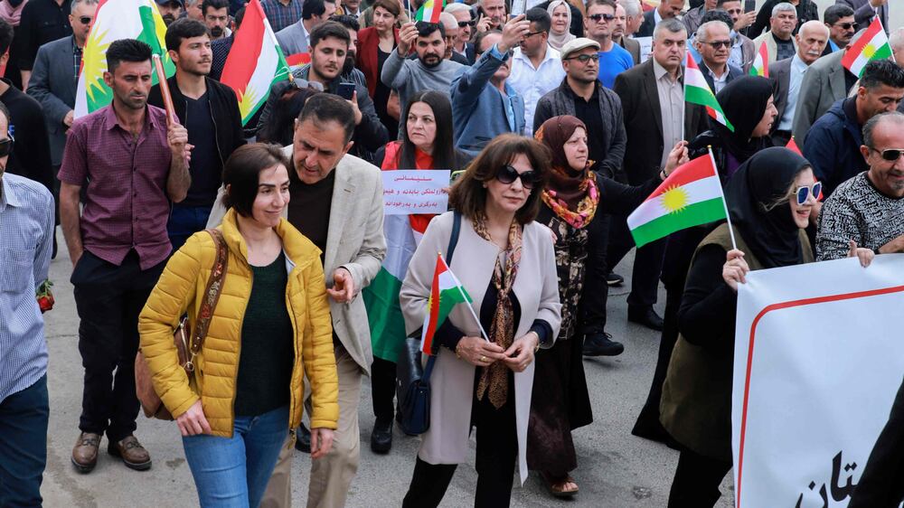 People lift banners and Kurdish flags during a demonstration in Sulaimaniyah in the autonomous Kurdish region of northern Iraq, on April 9, 2023, to protest reported Turkish bombardment of an airport in the region two days earlier.  (Photo by Shwan MOHAMMED  /  AFP)