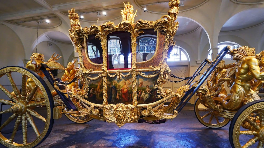 The Gold State Coach on display at the Royal Mews in Buckingham Palace, London, Tuesday April 4, 2023, in which King Charles III and the Queen Consort will return in to Buckingham Palace after the coronation on May 6.  King Charles III is taking a short cut and smoother ride to Westminster Abbey, trimming the procession route his mother took in 1953 as he aims for a more modest coronation that will include some modern touches, Buckingham Palace said Sunday April 9, 2023.  (Yui Mok / PA via AP)