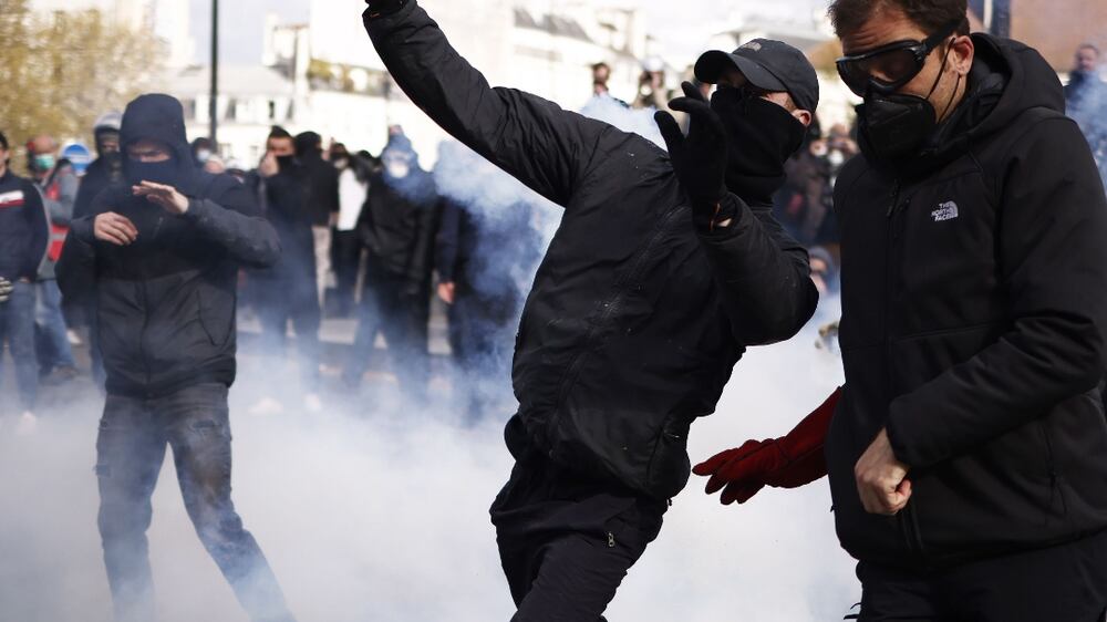 A protester throws a tear gas canister during clashes at a rally against the French government's pension reform in Paris, France, 13 April 2023.  The 'sages', members of the Constitutional Council, were due to deliver their verdict on 14 April concerning the examination of the text of the pension reform, almost one month after the country's prime minister announced the use of article 49. 3 of the French Constitution to have the text of the controversial bill to be definitively adopted without a vote.  The reform would raise the retirement age from 62 to 64.   EPA / YOAN VALAT