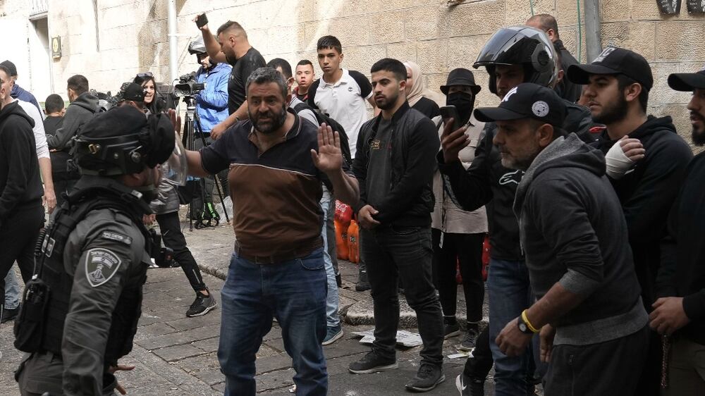 Israeli policeman tries to disperse Palestinians in the Old City of Jerusalem, Sunday, April 17, 2022.  Israeli police clashed with Palestinians outside Al-Aqsa Mosque after police cleared Palestinians from the sprawling compound to facilitate the routine visit of Jews to the holy site and accused Palestinians of stockpiling stones in anticipation of violence.  (AP Photo / Mahmoud Illean)