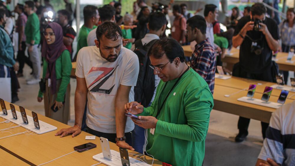 Customers browse iPhones at the new Apple Inc.  store in Mumbai, India, on Tuesday, April 18, 2023.  Chief Executive Officer Tim Cook officially opened Apple Inc. ’s first company-owned store in India, betting the iPhone maker’s retail outlets will help accelerate sales growth. Photographer: Dhiraj Singh / Bloomberg