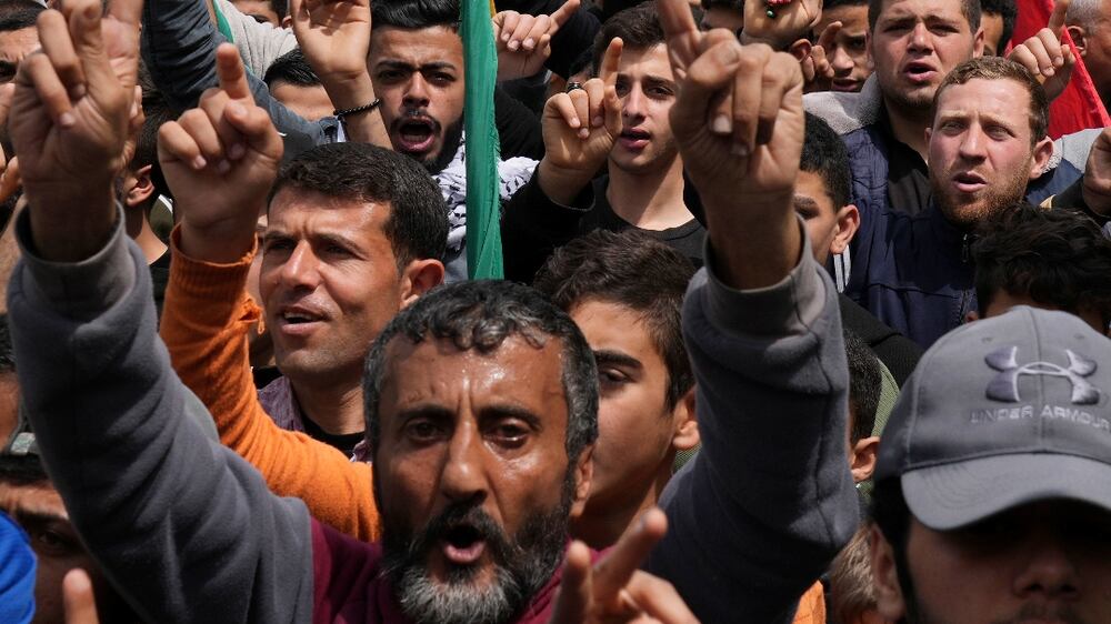 Hamas supporters wave green Islamic flags while raise their hands up and chant slogans during a rally in solidarity with Palestinian residents of the West Bank and Jerusalem, at the main road of Jebaliya refugee camp, northern Gaza Strip, Friday, April 22, 2022.  (AP Photo / Adel Hana)