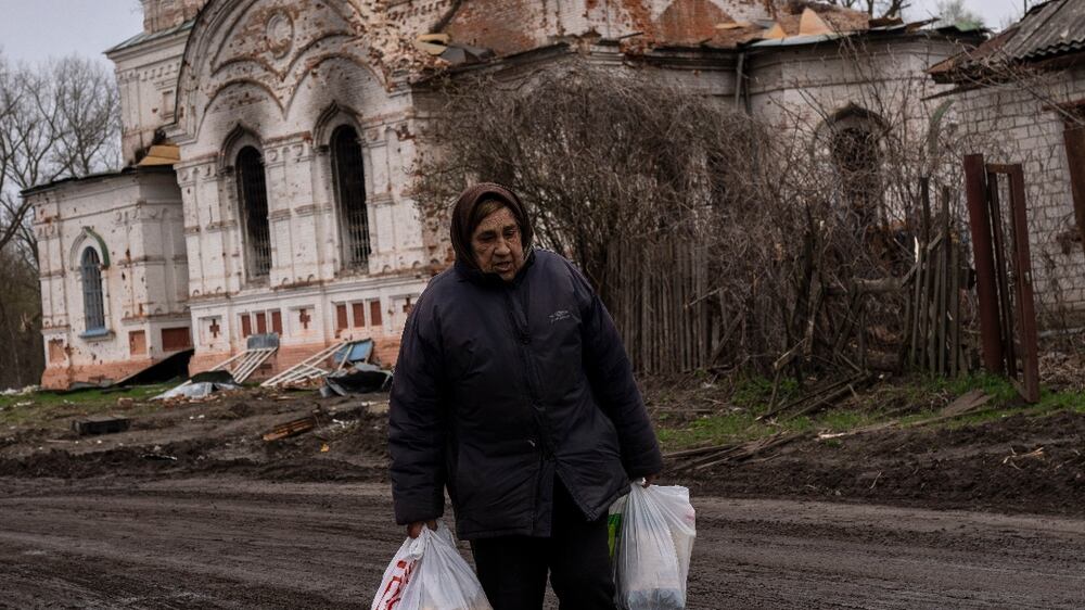 Valentyna Bushtruk , 70 walks in front of a damaged church, in Lukashivka, in northern Ukraine, on Friday, April 22, 2022.  A single metal cross remains inside the Orthodox church of shattered brick and blackened stone.  Residents say Russian soldiers used the house of worship for storing ammunition, and Ukrainian forces shelled the building to make the Russians leave.  (AP Photo / Petros Giannakouris)