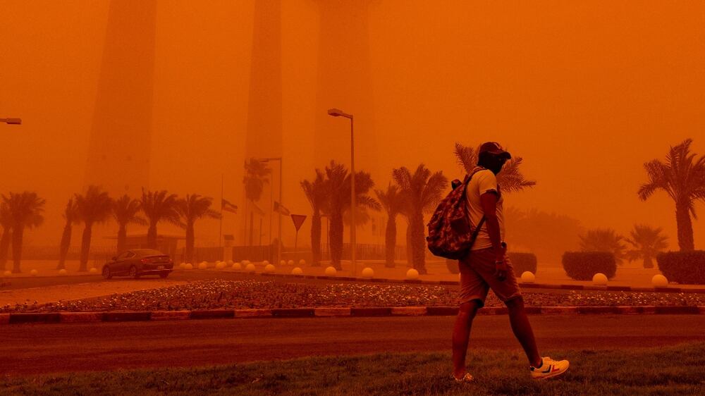 A man walks past the Kuwait Towers shrouded in heavy dust in Kuwait City, Kuwait, 23 May 2022.  Sandstorms affected several countries across the Middle East in recent days, including Iraq, Iran, Kuwait, Saudi Arabia and the UAE, as health experts warn of the respiratory risks sand storm might cause.   EPA / NOUFAL IBRAHIM